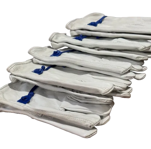 Stack of white gloves with blue accents on a patterned fabric background