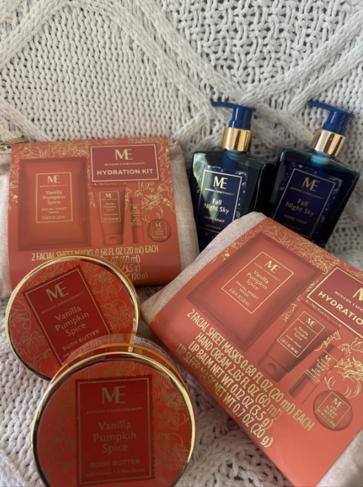 Cosmetic products including a red box, two blue bottles, and a gold compact on a textured white background.