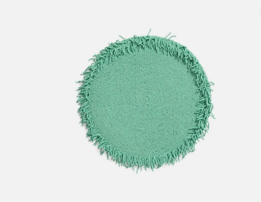 Round green rug with frayed edge on a white background