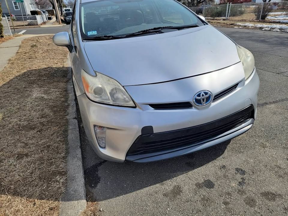 Front view of a silver 2013 Toyota Prius parked on the street near a curb in Stratford, Connecticut, showing minor cosmetic wear