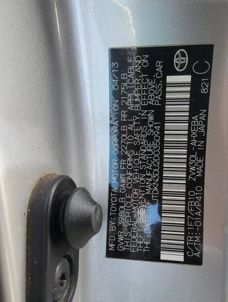 Close-up of the manufacturer’s VIN sticker on a 2013 Toyota Prius, showing production date 04/13 and VIN JTDKN3DU0D0350941.