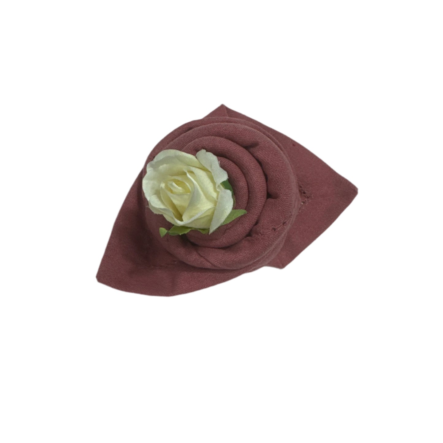 A neatly rolled cotton napkin in a rich rose color, adorned with a small artificial white rose and green leaves, showcasing a decorative and elegant fold