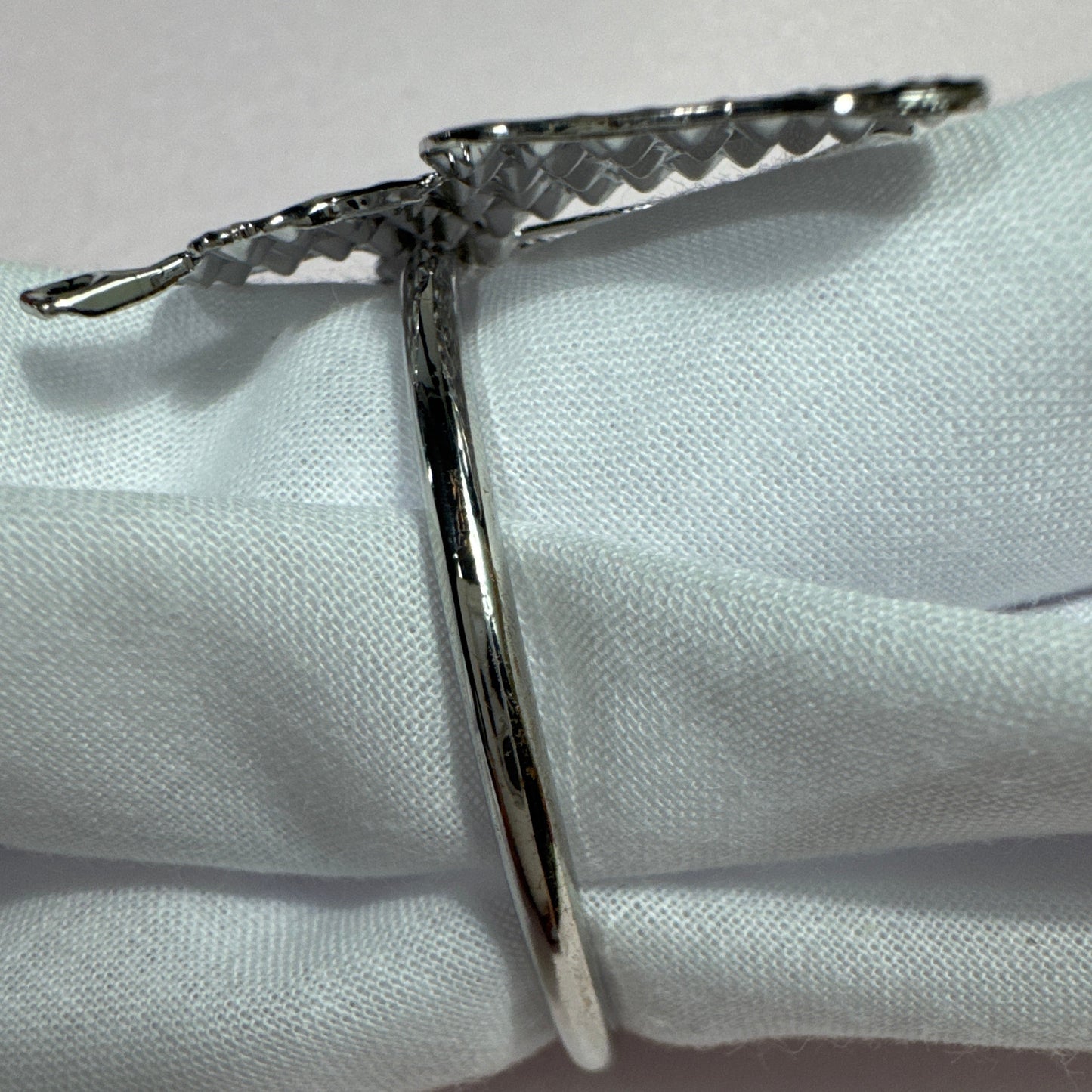 Set of 6 silver butterfly napkin rings displayed on cloth napkin and dish.

